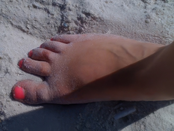 a person's foot with a red nail