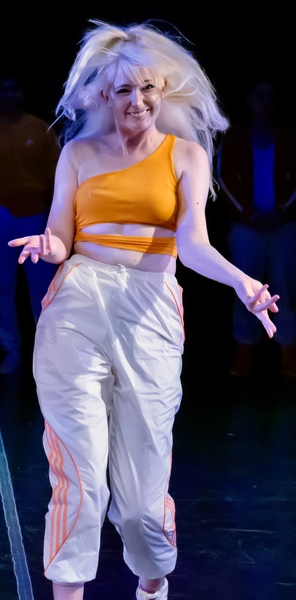 a woman in a yellow top and white pants