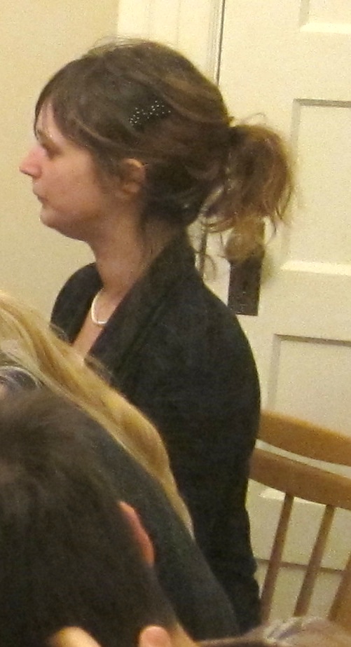 a woman sitting at a table with a bunch of bananas