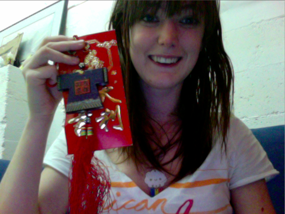 a woman holding a red box with a red and gold design