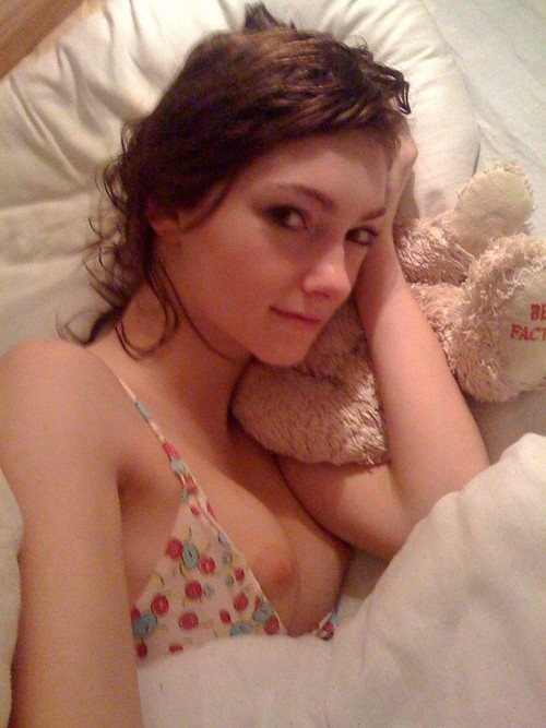 a woman laying in bed with a teddy bear