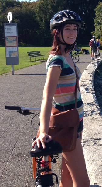 a woman riding a bike down a road