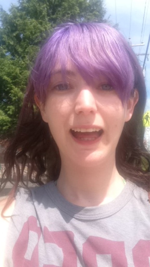 a woman with purple hair and a grey shirt