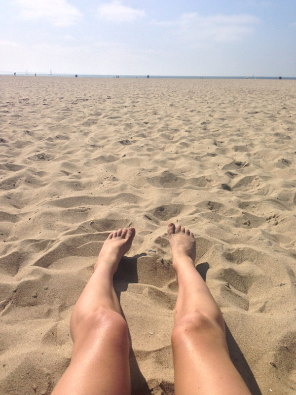 a person's feet in the sand at the beach