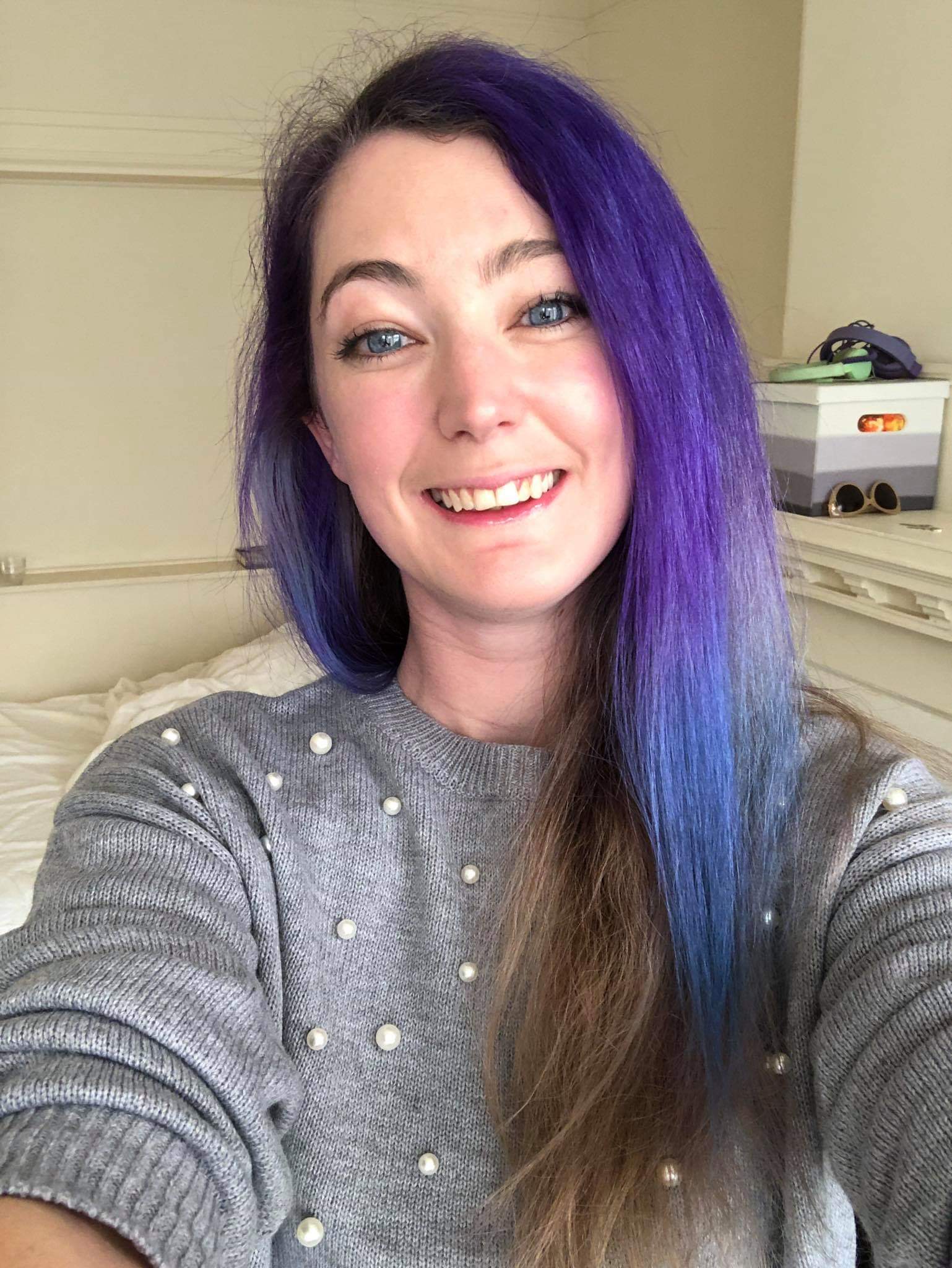 a woman with purple hair and blue eyes