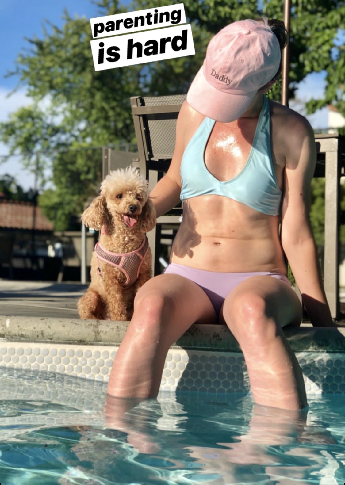 a woman in a bikini and hat sitting on a pool