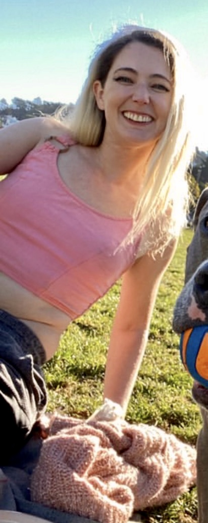 a woman sitting on a blanket with a dog