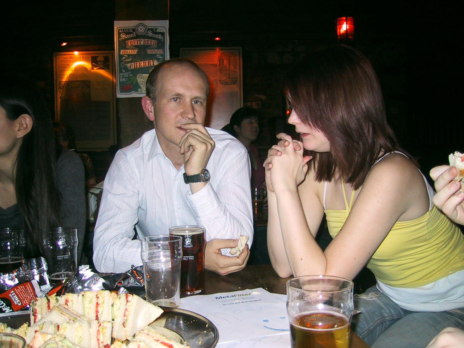 a man and woman sitting at a table eating food _