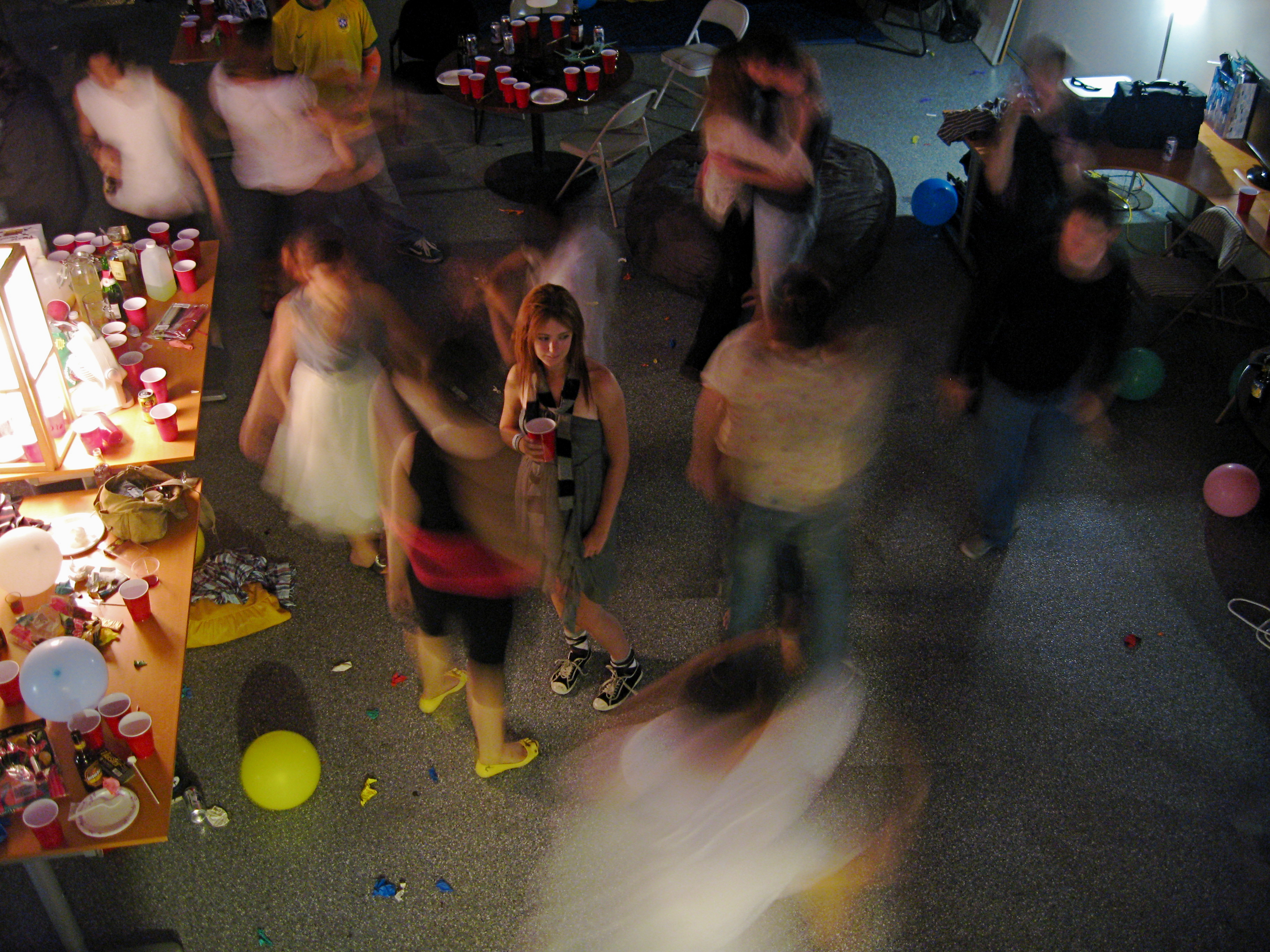 a group of people dancing around a table