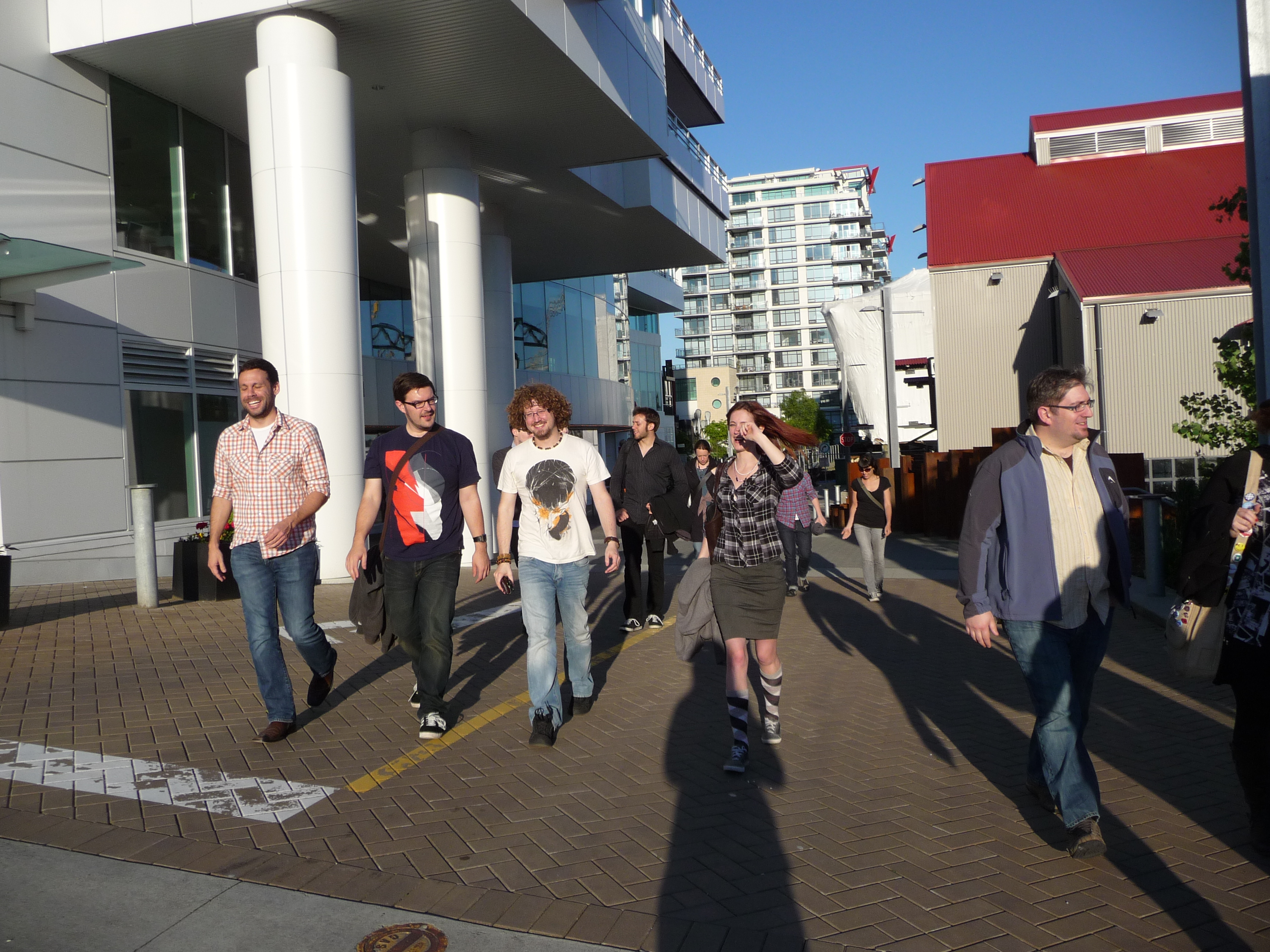 a group of people walking down a sidewalk