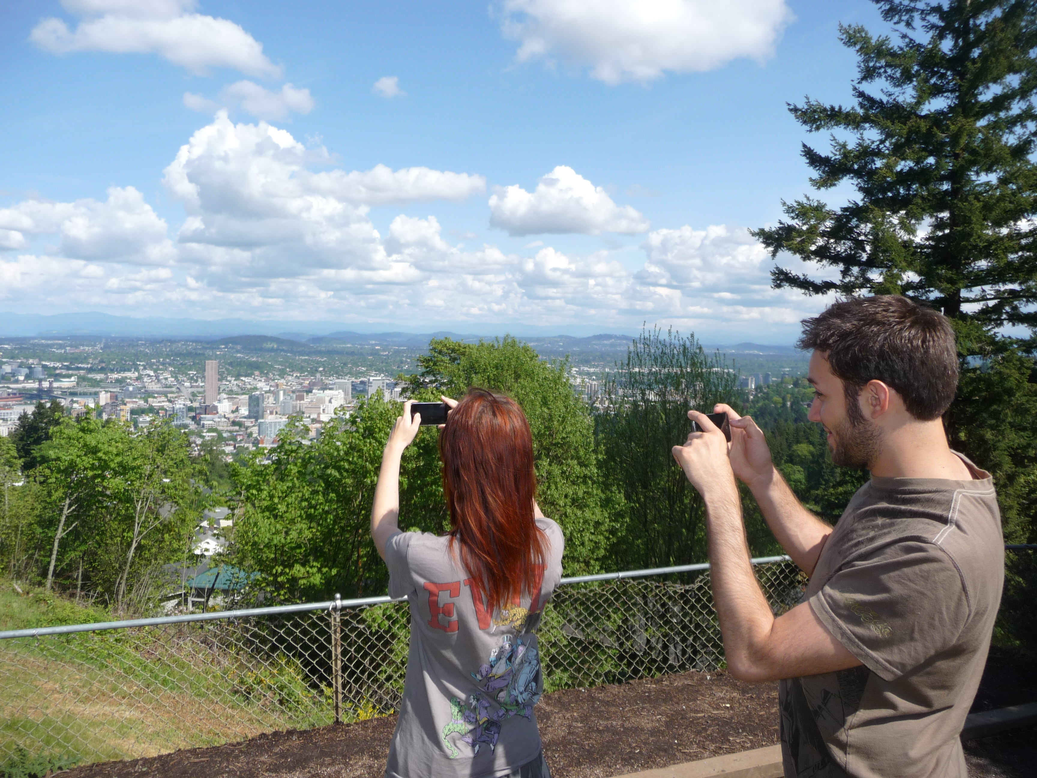 a man and woman taking a picture of a city