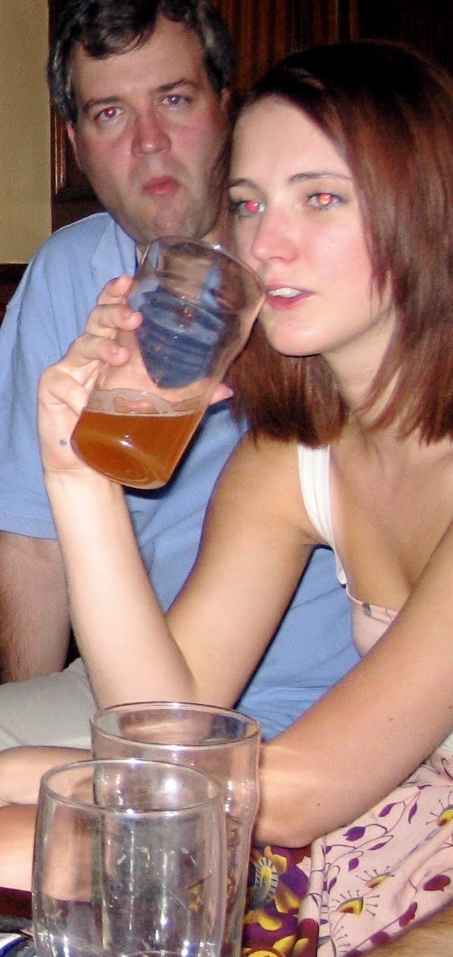 a man and woman sitting at a table with drinks