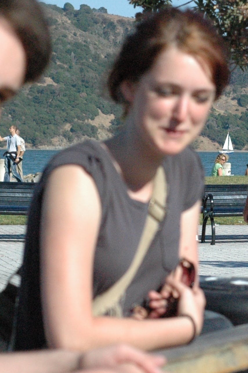 a woman sitting on a bench with a cellphone in her hand