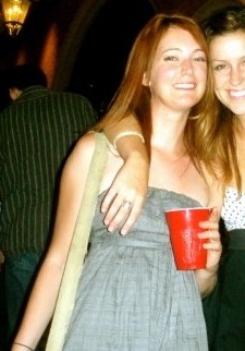 two girls are standing together at a party