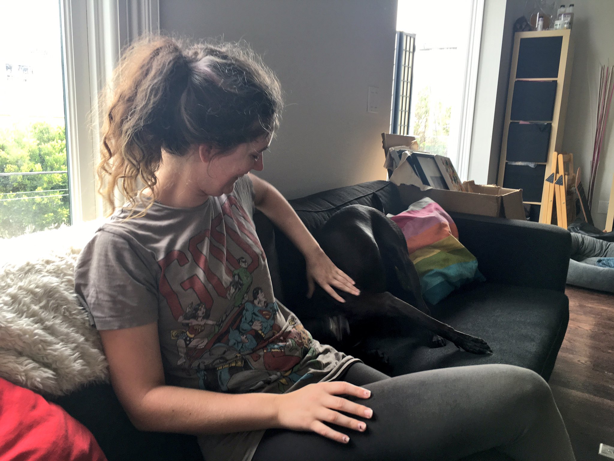 a woman sitting on a couch with a dog