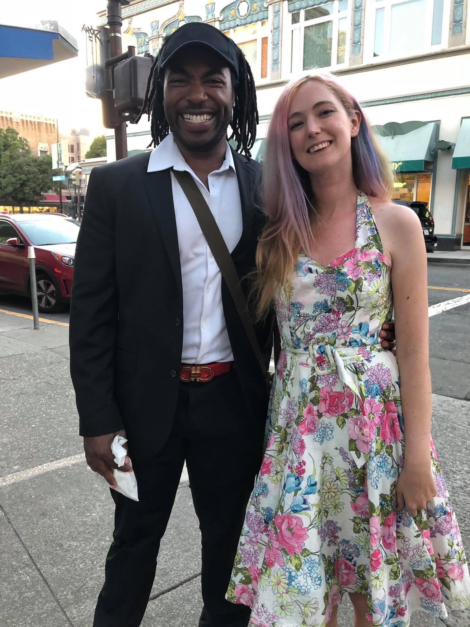 a man in a suit and tie standing next to a woman in a dress