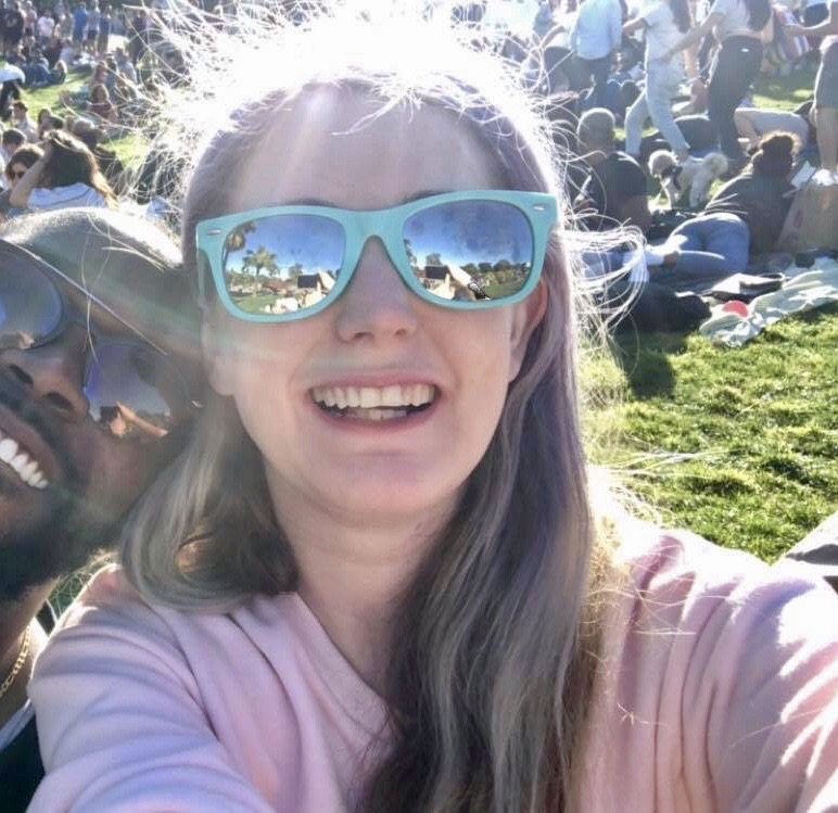 a woman in sunglasses and a man in a pink shirt