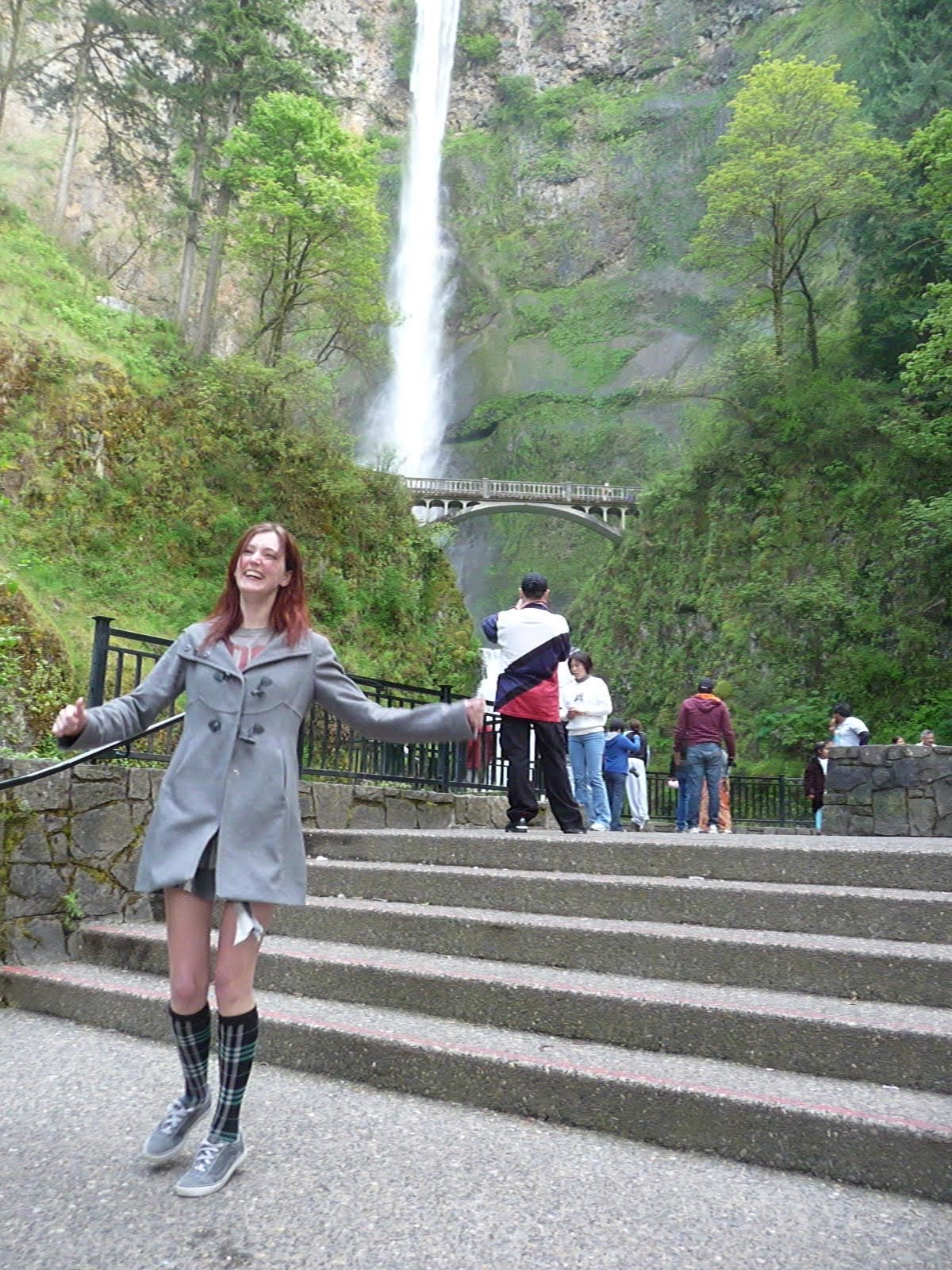 a woman in a gray coat is standing on some steps af

zg