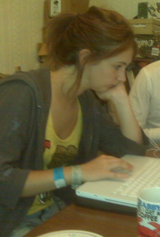 a woman sitting at a table with a laptop