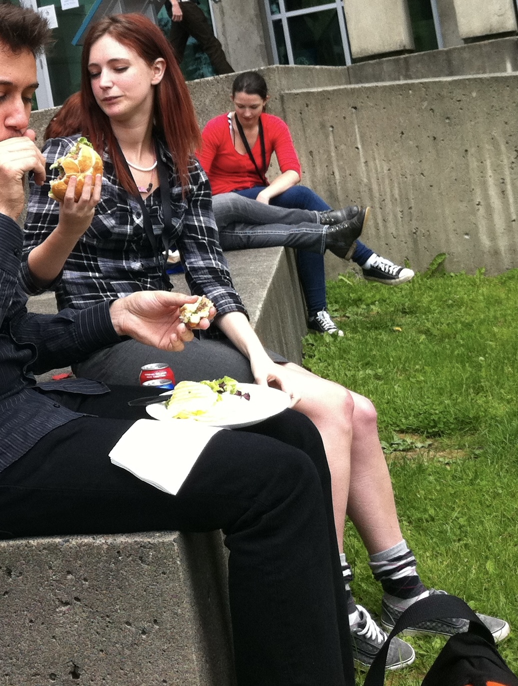 a man and woman eating food on a bench