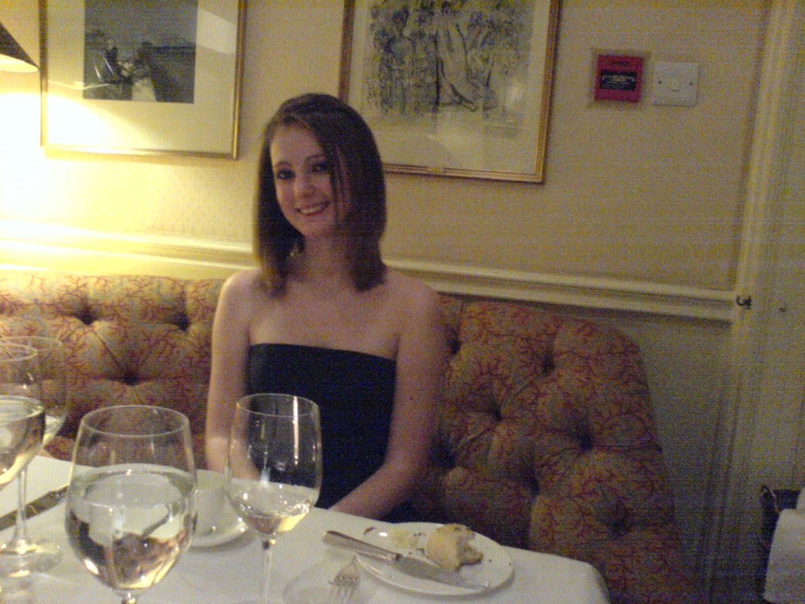 a woman sitting at a table with a glass of wine