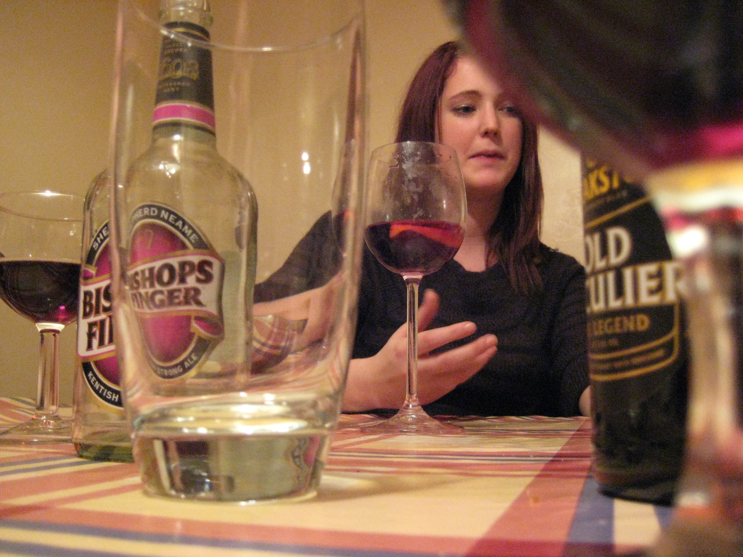 a woman sitting at a table with a glass of wine