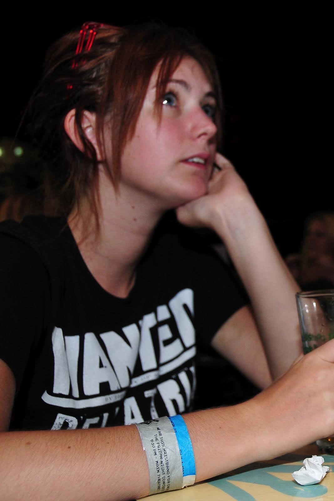 a woman sitting at a table with a glass of wine