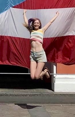 a woman jumping in the air with a flag