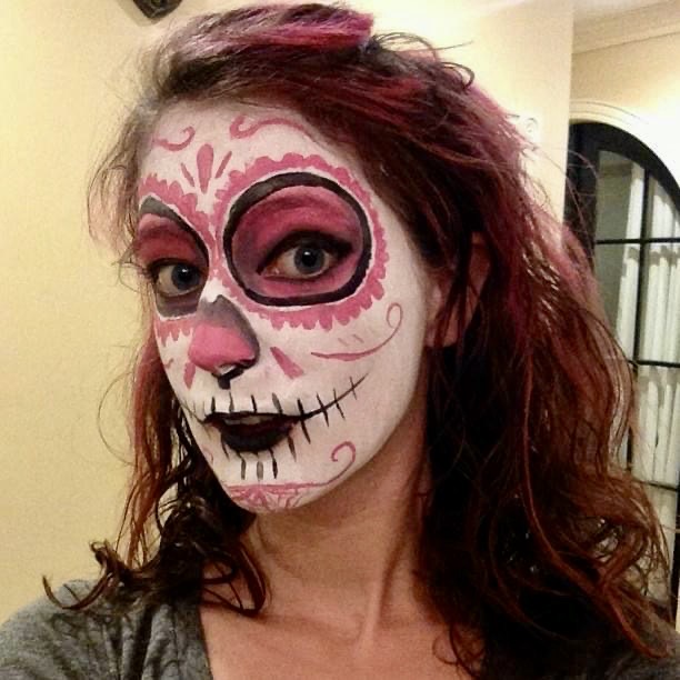 a woman with a face painted in pink and white