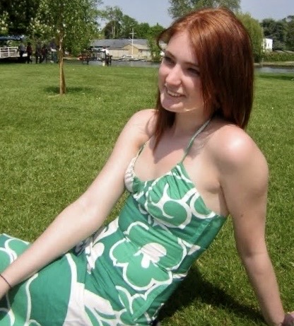 a woman in a green dress sitting on the grass