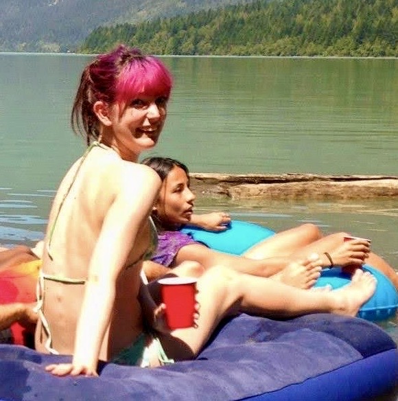 two girls are sitting on an inflatable