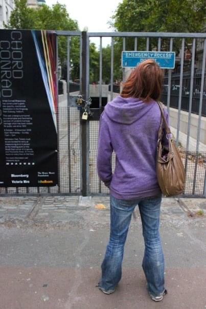 a woman standing in front of a fence