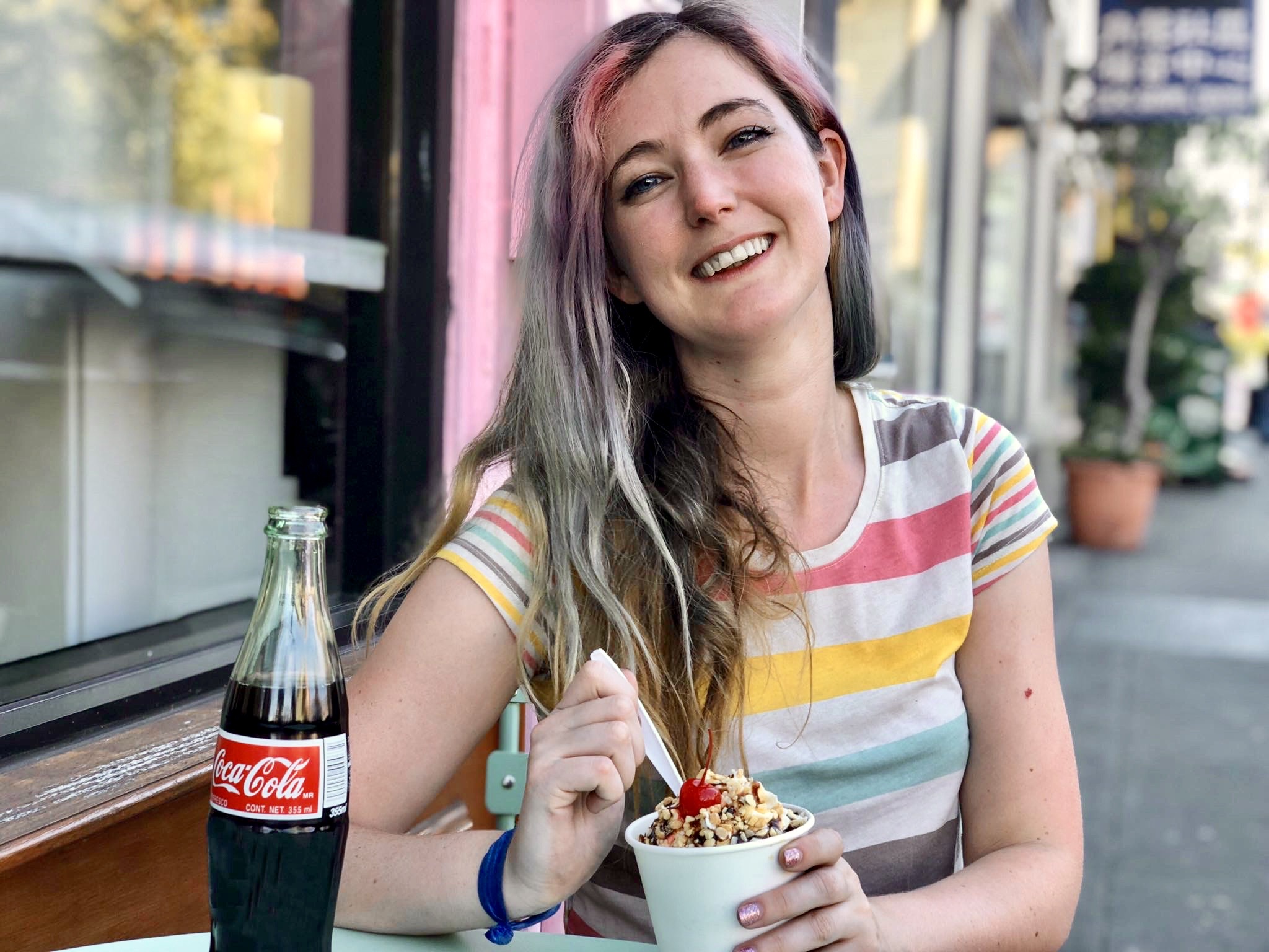 a woman sitting at a table eating a bowl of food