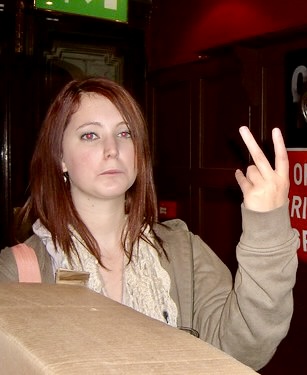 a woman holding a box of pizza