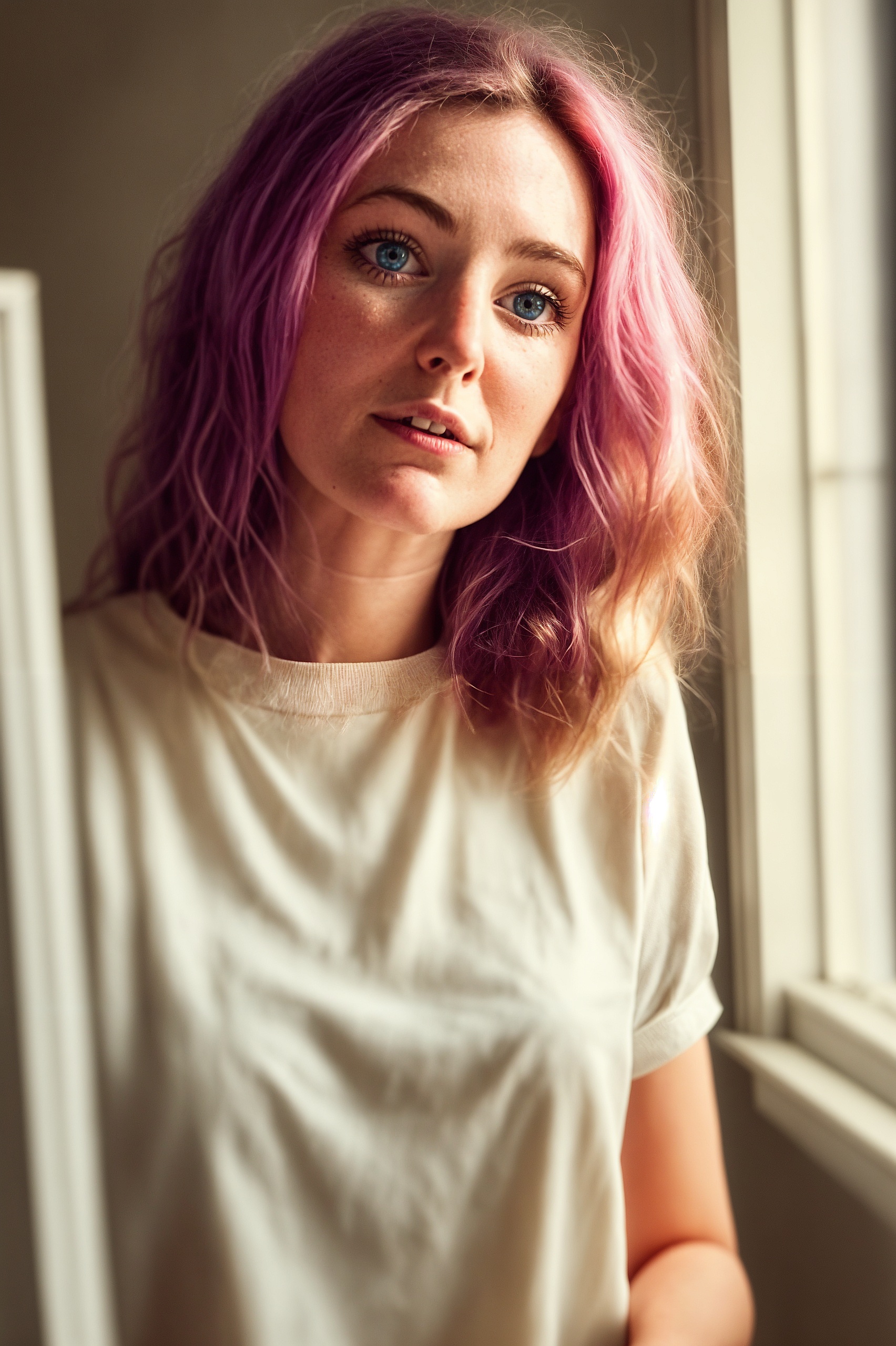 a woman with pink hair and blue eyes