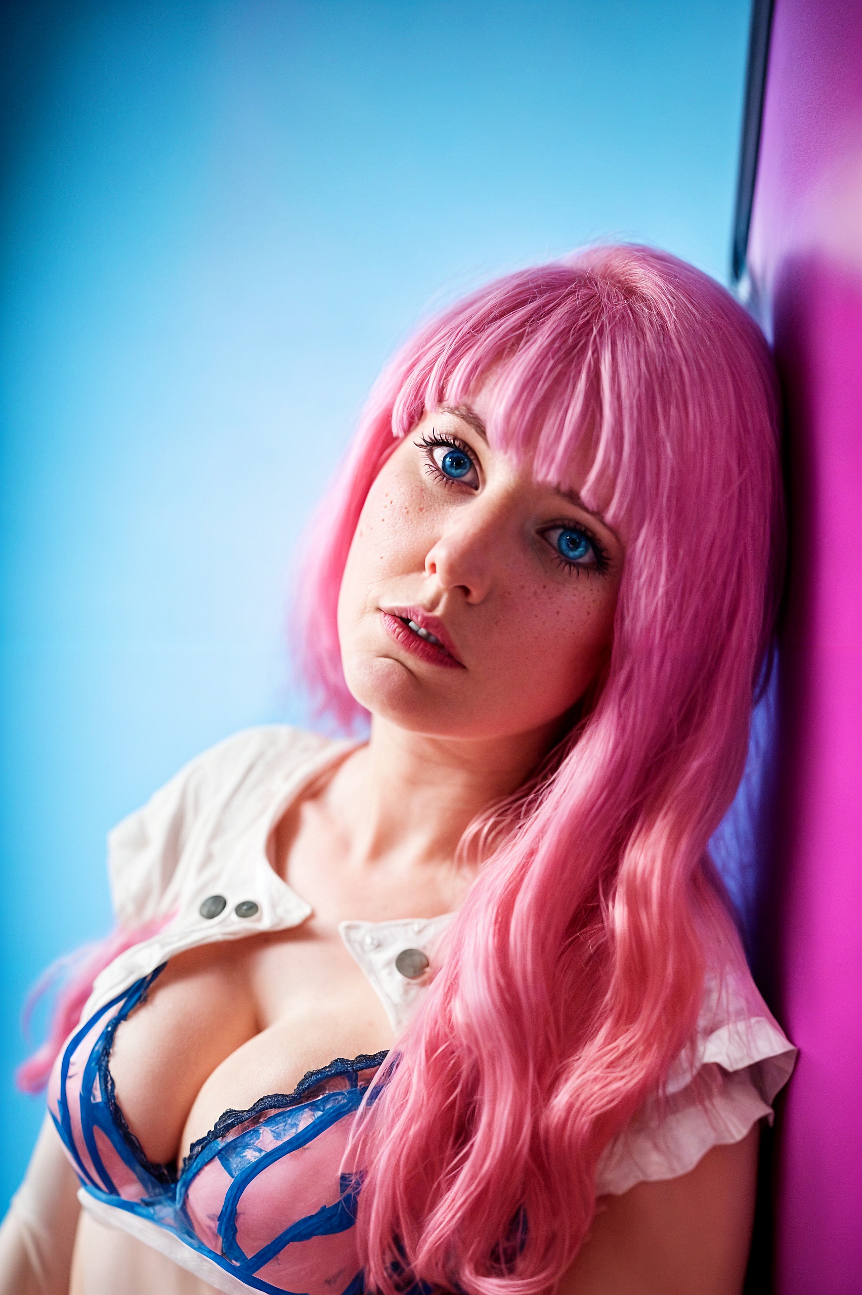 a woman with pink hair and blue eyes