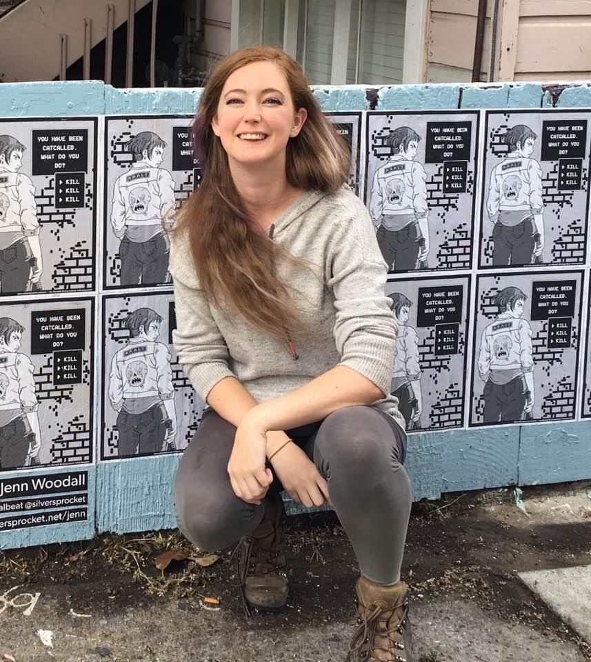 a woman sitting on the ground in front of a wall with posters Jenn Woodall
sprocket
yen

Tpeat sien
———