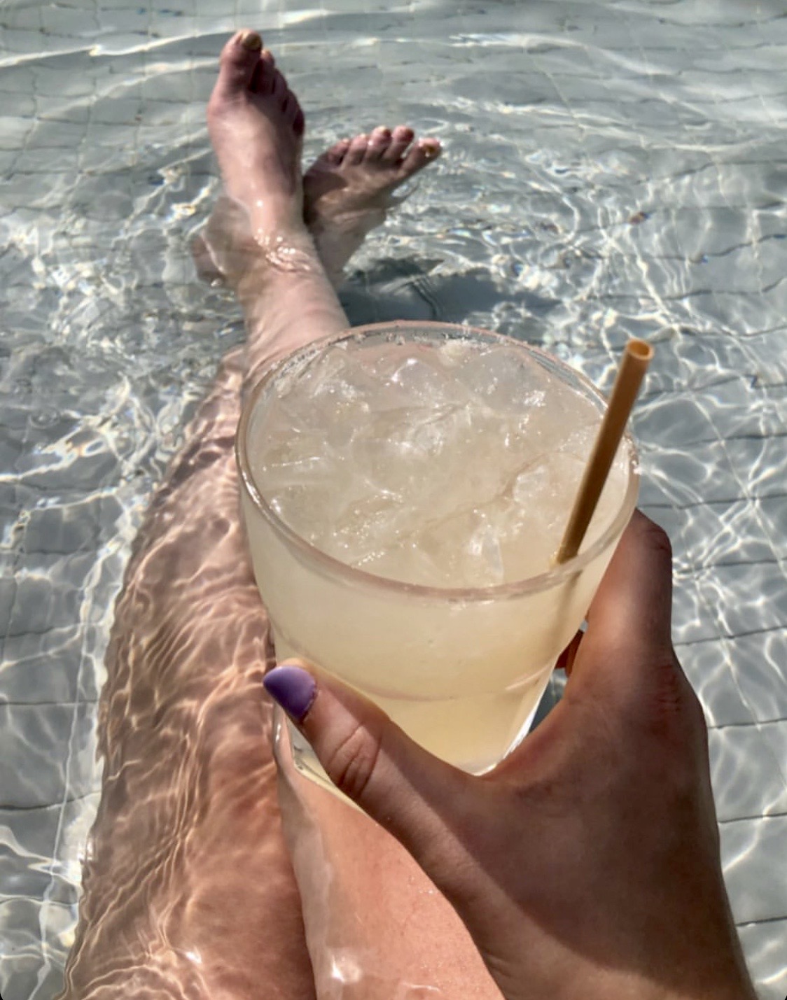 a person holding a drink in the water