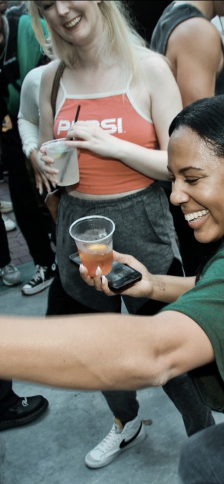 a woman is holding a drink in her hand