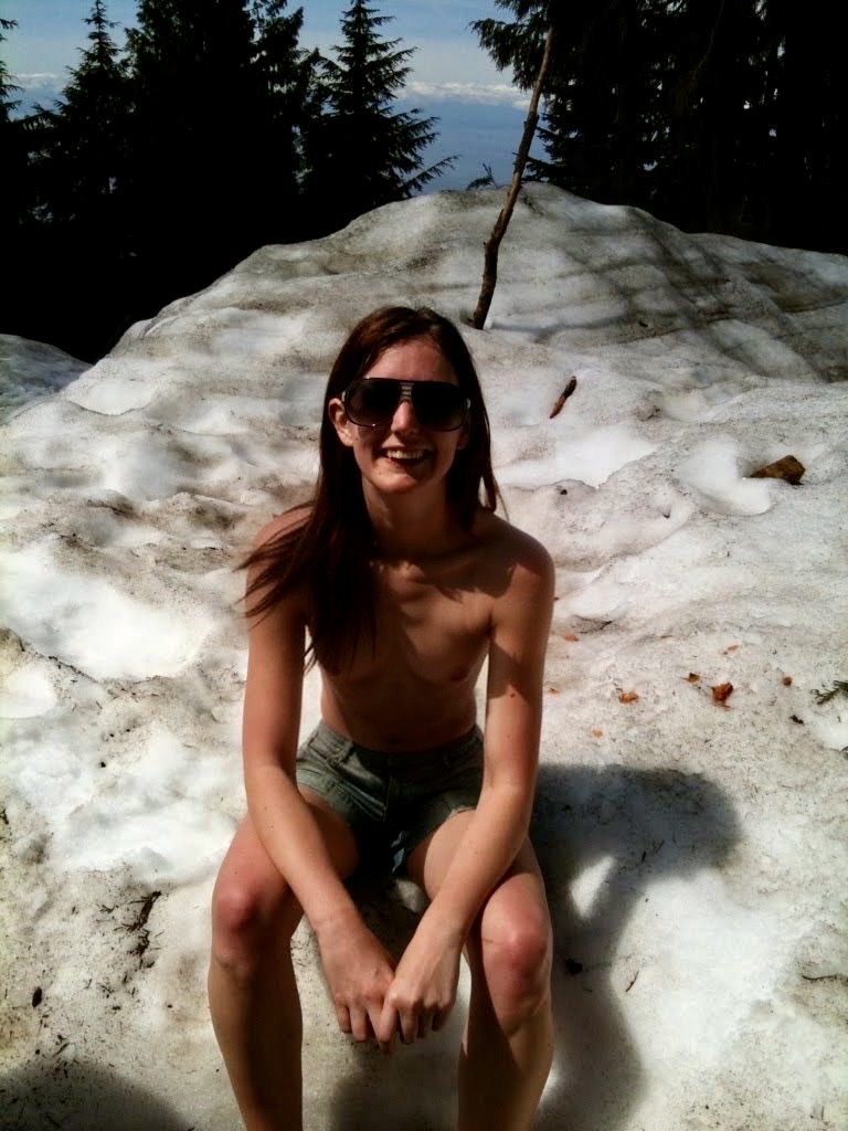 a woman sitting on a rock in the sand