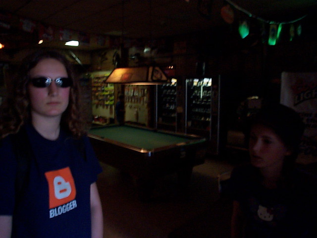 a woman standing in a room with a pool table