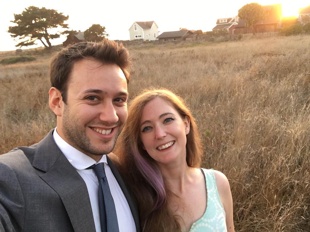 a man and woman standing in a field