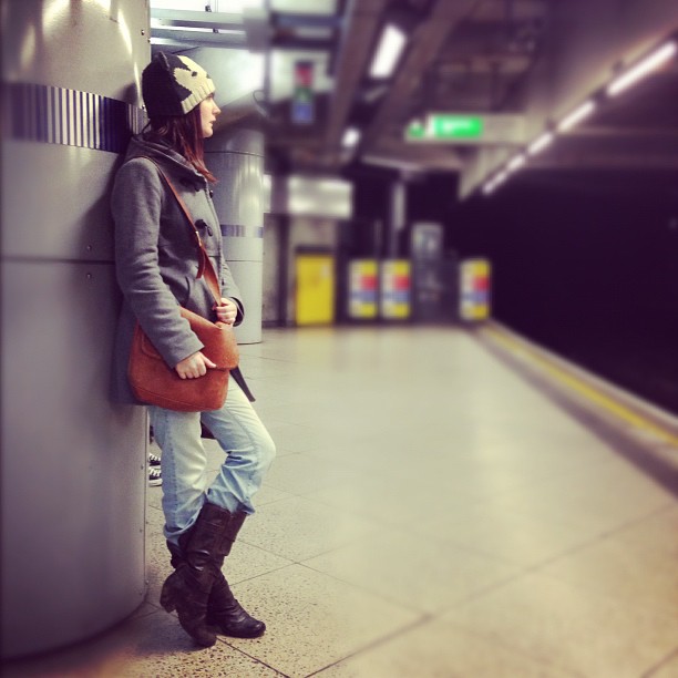 a woman is standing in a subway station