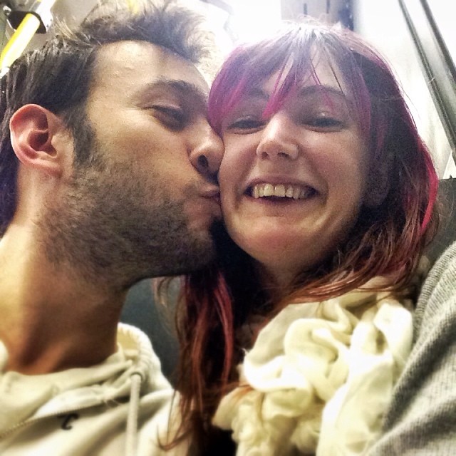 a man and woman are kissing on a train