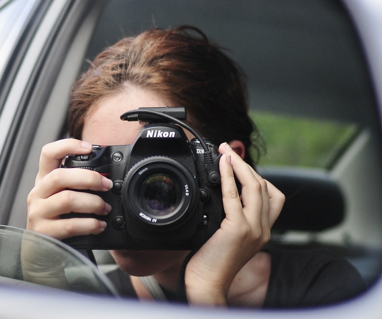 a woman taking a picture of herself in a car