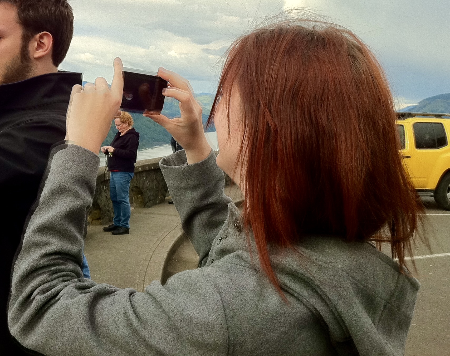 a man and woman taking a picture of a yellow van