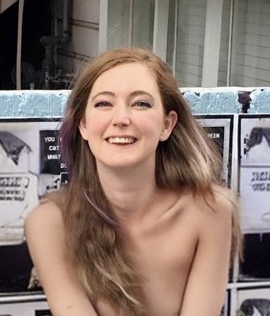 a woman sitting on a bed with a white sheet