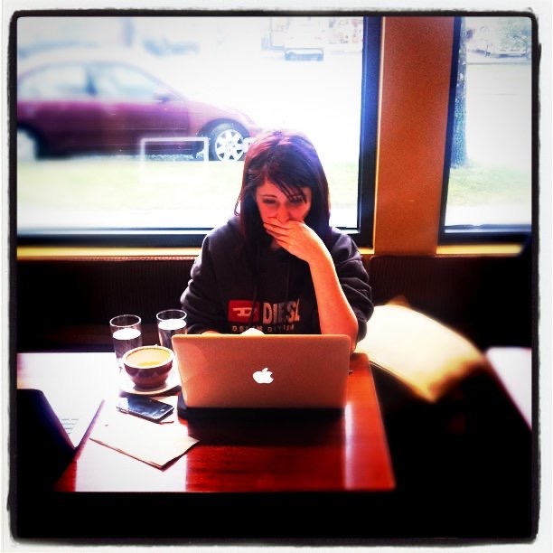 a woman sitting at a table with a laptop