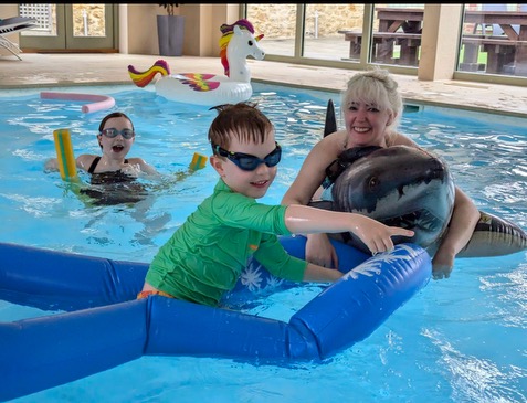 a woman and two children in a pool