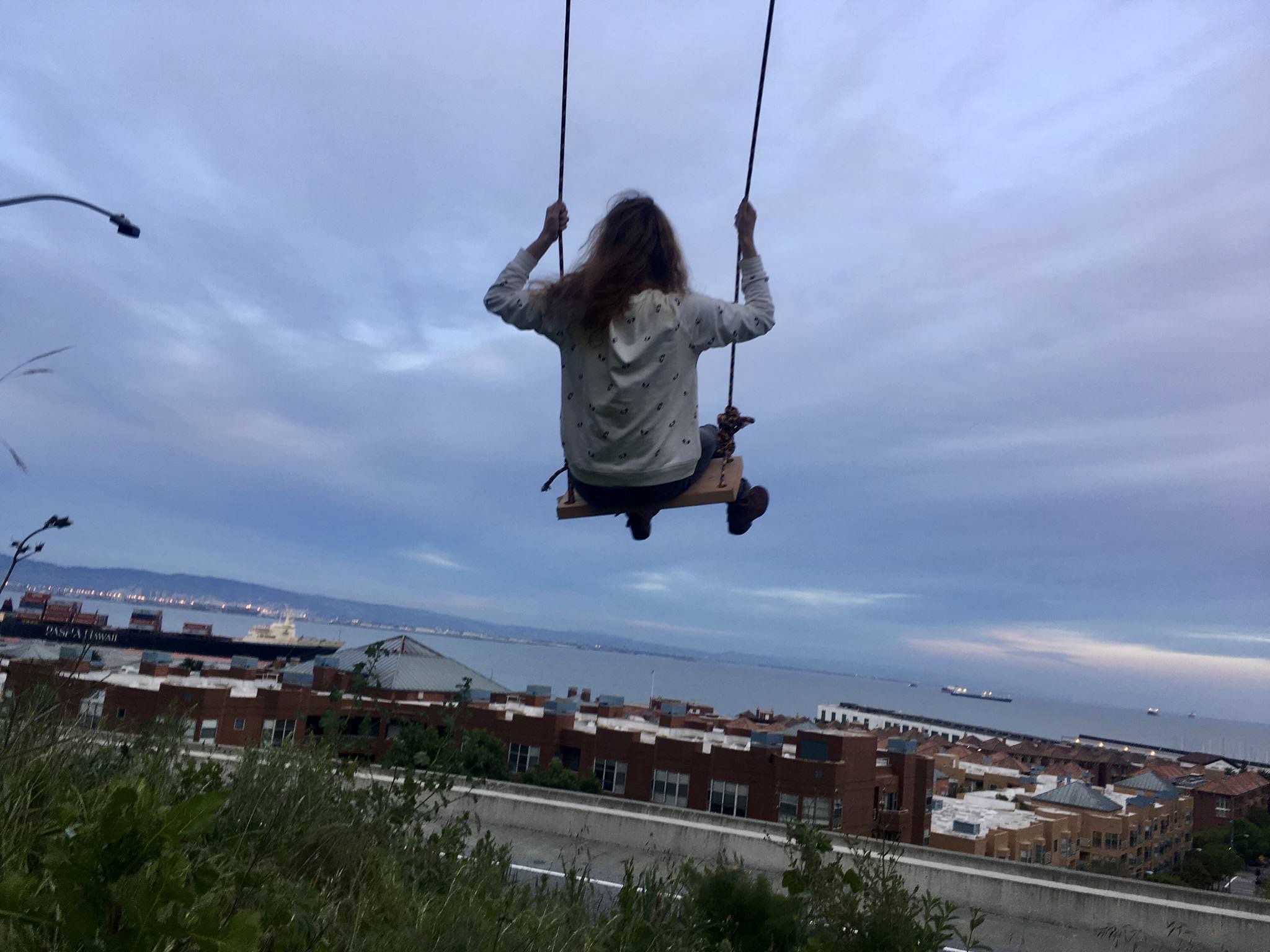 a woman is swinging on a swing in the air